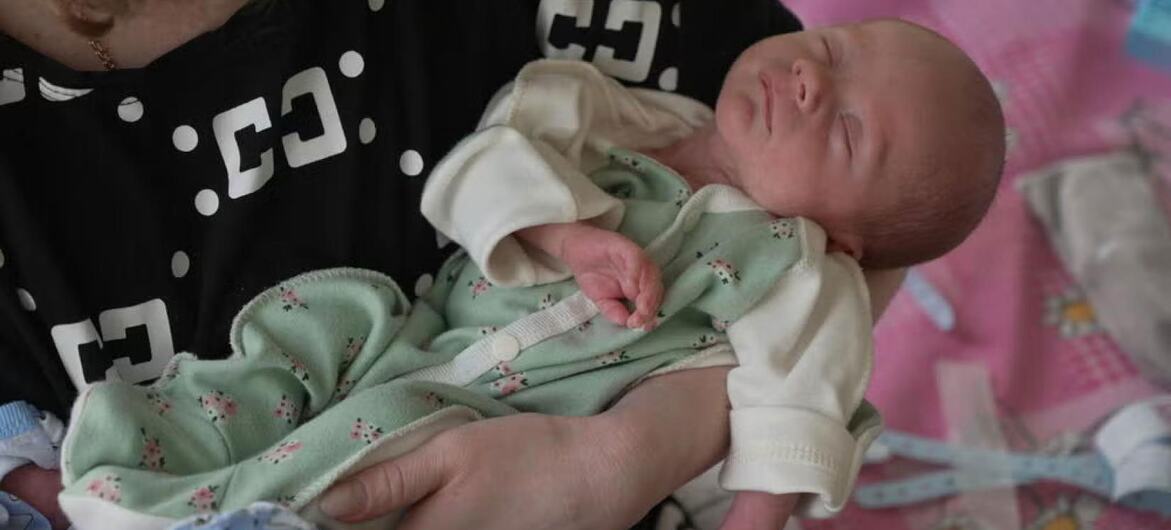 A Ukrainian mother holds a newborn baby in her arms.