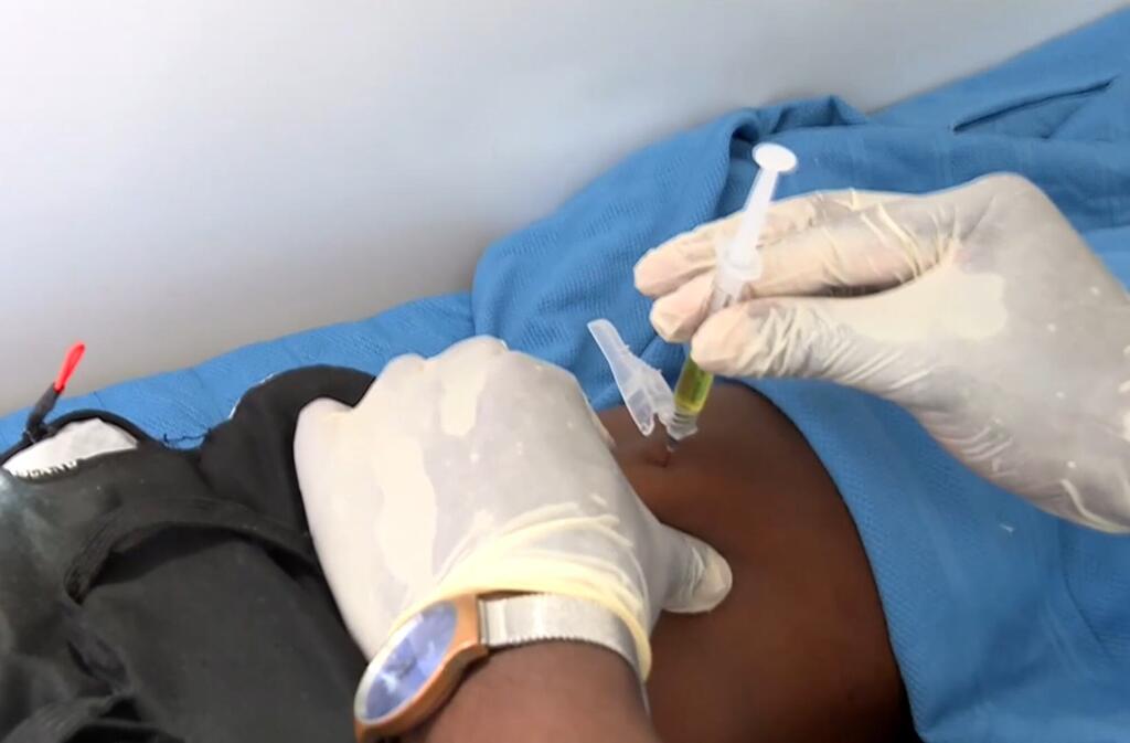 Mfanyakazi wa afya akimdunga mgonjwa sindano mkononi wakati wa jaribio la chanjo ya VVU ya UNAIDS nchini Zimbabwe.