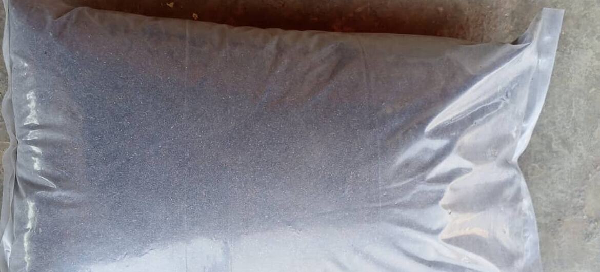 Mfuko wa plastiki ulio wazi uliojaa mbolea ya kikaboni nyeusi iliyotengenezwa kwa kinyesi cha nywele za binadamu.