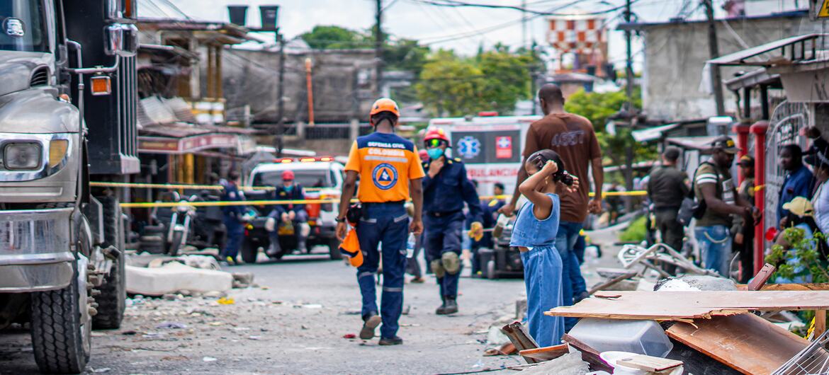 Los equipos de emergencia caminan por una calle llena de escombros tras el desastre ocurrido en Colombia.