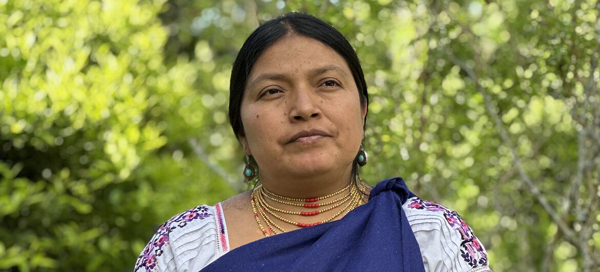 Retrato de una mujer ecuatoriana con vestimenta tradicional, de pie al aire libre.