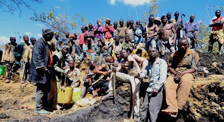 Um grande grupo de garimpeiros do sexo masculino posa para uma fotografia em um sítio arqueológico em Cabo Delgado, Moçambique.