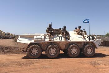 Des soldats de la paix mongols de la MINUSS circulent à bord d'un véhicule blindé de transport de troupes blanc à Bentiu, dans le Haut-Nil.