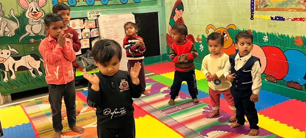 Um grupo de crianças indianas participa de uma atividade em sala de aula em um centro de cuidados infantis apoiado pelo PNUD na Índia.