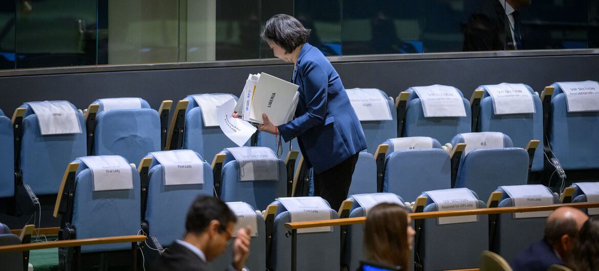 联合国礼宾工作人员在第80届联合国大会辩论开始前，将国家名称卡放在联合国堂预留的蓝色座位上。