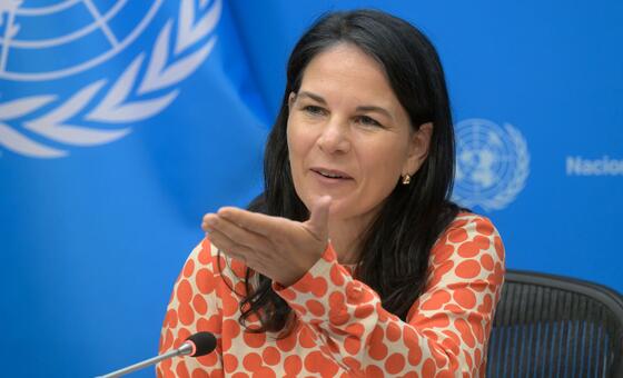 Annalena Baerbock, présidente de la 80e session de l'Assemblée générale des ONU , prend la parole au micro, le drapeau de ONU figurant en arrière-plan.