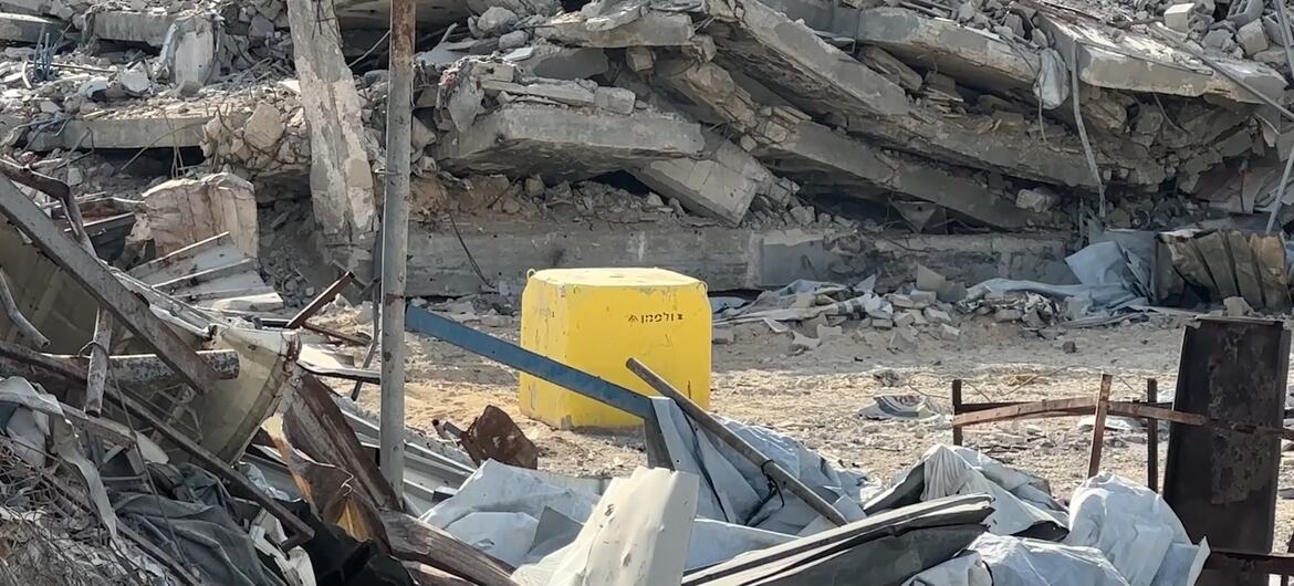 A yellow barrier sits amid extensive rubble and collapsed concrete in Gaza.