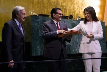 UN Secretary-General Antonio Guterres looks on as the outgoing and incoming Presidents of the 80th and 81st sessions of the United Nations General Assembly exchange a ceremonial wooden plaque at the UNGA opening in New York.