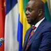 Martin Kimani, Mwakilishi wa Kudumu wa Kenya katika UMOJA WA MATAIFA, akizungumza kwenye kipaza sauti wakati wa mkutano akiwa na bendera za kitaifa nyuma yake.