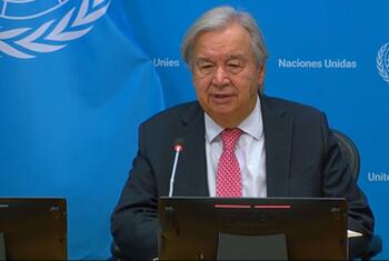 يتحدث الأمين العام الأمم المتحدة أنطونيو غوتيريش من على طاولة أمام خلفية زرقاء United Nations خلال فعالية للجمعية العامة.