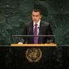 Daniel Noboa, presidente de Ecuador, se encuentra en un podio con el emblema de la ONU , hablando ante micrófonos con un fondo de mármol verde.