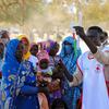 Une agente de santé de UNICEF et de la Croix-Rouge fait la démonstration d'un ruban métrique pour mesurer le tour de bras à des mères africaines tenant des nourrissons lors d'une séance en plein air dans le camp de réfugiés de Marassabré au Tchad.