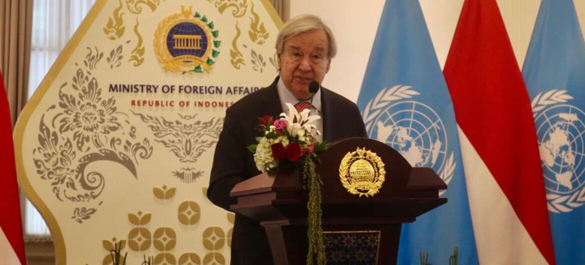 UN Secretary-General António Guterres speaks at a floral podium before national and United Nations flags at the Ministry of Foreign Affairs.