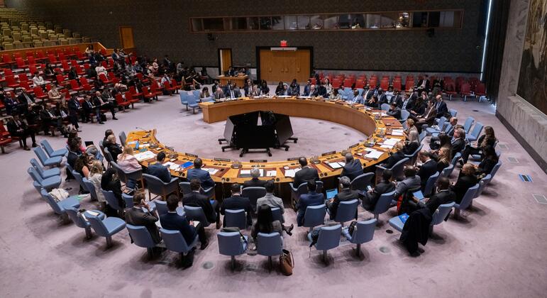 Делегаты сидят вокруг стола в форме подковы в Совете Безопасности United Nations во время официального заседания в Нью-Йорке.