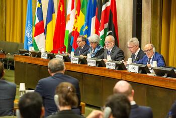 Delegates from Switzerland, the United Nations, the African Union, and IGAD sit at a long conference table with nameplates and national flags behind them during a Sudan peace coordination meeting at the Palais des Nations in Geneva.