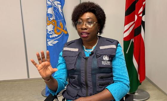 Dr. Neema Rusibamayila Kimambo, WHO Representative in Kenya, gestures while speaking in front of United Nations and Kenyan flags.
