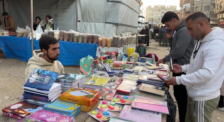 يتصفح شباب فلسطينيون الكتب في بسطة يعمل بها الشاب مصطفى صادق في سوق خان يونس، جنوب غزة.