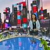 Uma mulher e um homem examinam um modelo arquitetônico detalhado de uma cidade na Conferência do Fórum Urbano Mundial.