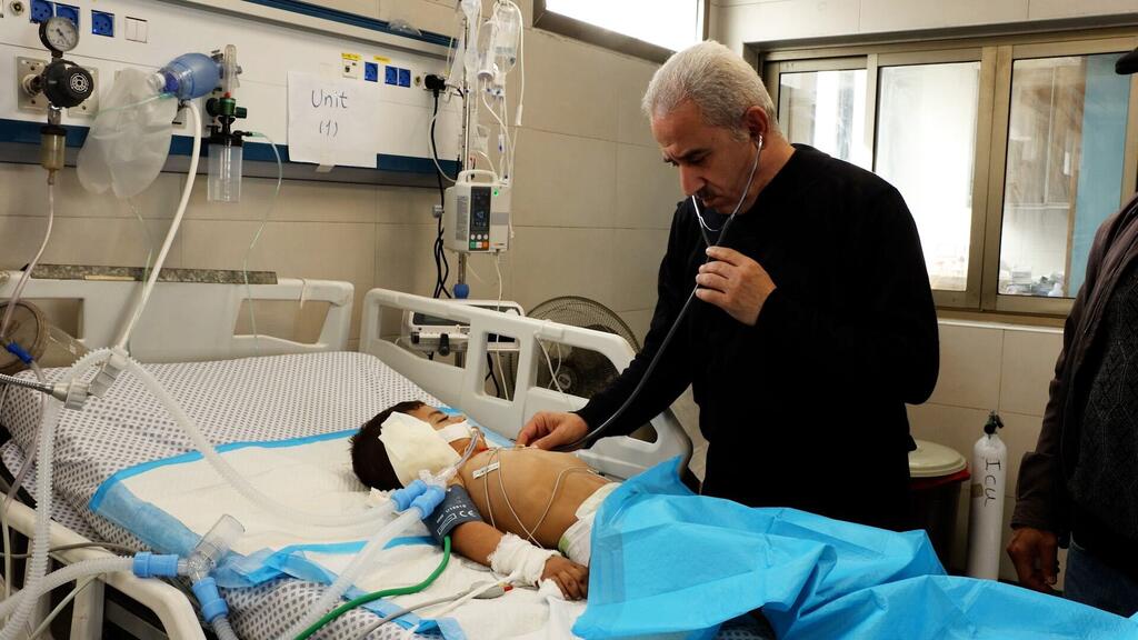 الدكتور رفعت جندية أثناء فحص أحد الأطفال المرضى في مستشفى الشفاء بمدينة غزة.
