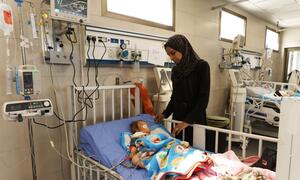 Balqees Abu Ajwa, the mother of eight-month-old Sama Abu Ajwa, is standing next to her daughter's bed, who is hospitalized and suffering from acute kidney failure.