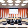 Large vue de la chambre du Conseil économique et social des Nations Unies (ECOSOC) lors d'une réunion officielle avec des délégués assis à des bureaux avec des pancartes d'organisations internationales telles que la Banque mondiale, le FMI, l'OMS, l'OMPI et le FIDA.
