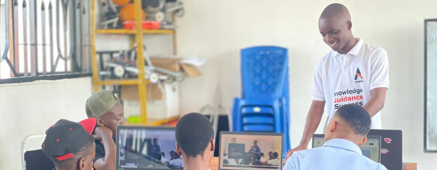 Os estudantes da Tanzânia participam de uma aula de educação em TIC, usando laptops e guiados por um professor em um ambiente de laboratório informático.