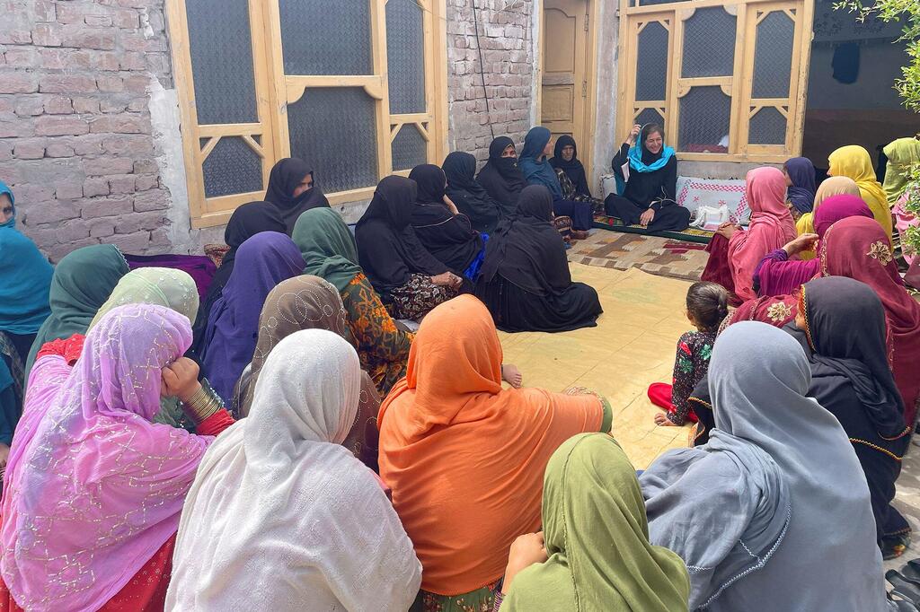 Stephanie Loose, responsable du programme pays d'ONU-Habitat en Afghanistan, s'adresse à un groupe de femmes dans une cour en Afghanistan.