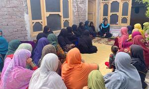 Stephanie Loose, Meneja wa Programu ya Nchi ya UN-Habitat Afghanistan, anazungumza na kikundi cha wanawake katika uwanja wa nyumbani nchini Afghanistan.