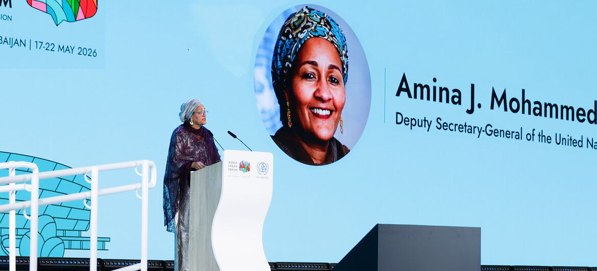 Amina Mohammed, secrétaire générale adjointe des Nations Unies, s'exprime sur un podium lors du Forum urbain mondial (WUF13) à Bakou, en Azerbaïdjan. Un grand écran derrière elle affiche son portrait et son nom.