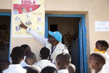 UNICEF WASH Officer Ciza Nyalundja explains Ebola prevention measures to pupils at a school in Bunia, Ituri Province, DR Congo.