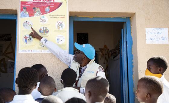 UNICEF WASH Officer Ciza Nyalundja explains Ebola prevention measures to pupils at a school in Bunia, Ituri Province, DR Congo.