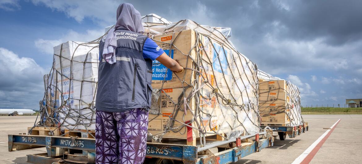 A World Health Organization staff member in Nairobi secures a pallet of emergency medical supplies on an airport tarmac.