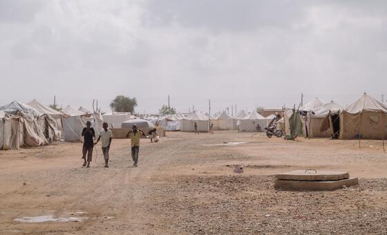 Children walk at a camp for displaced persons in Port Sudan, which is hosting families who fled violence across the country, including Darfur and Kordofan regions.