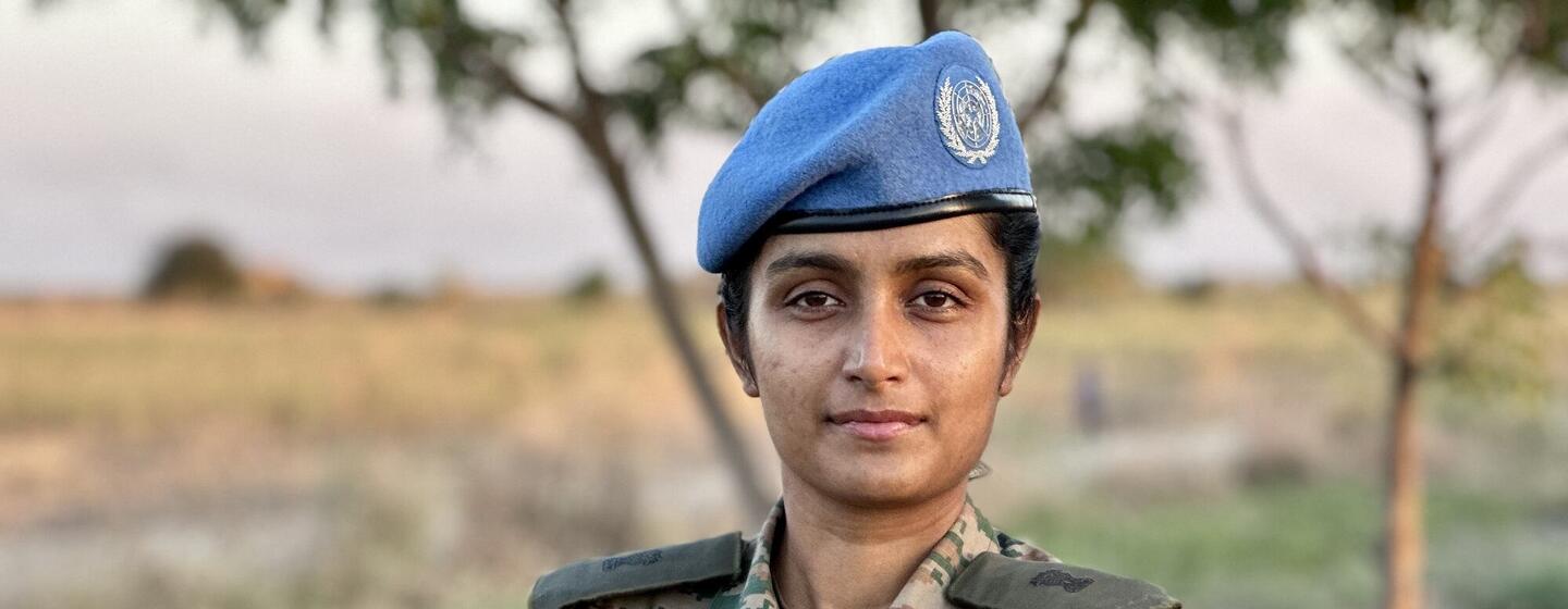 दक्षिण सूडान में तैनात भारतीय सेना की एक महिला शांति सैनिक, स्वती एस, यूएनएमआईएसएस चिह्न और भारतीय ध्वज पैच के साथ अपने छलावरण वर्दी में आत्मविश्वास से खड़ी है।