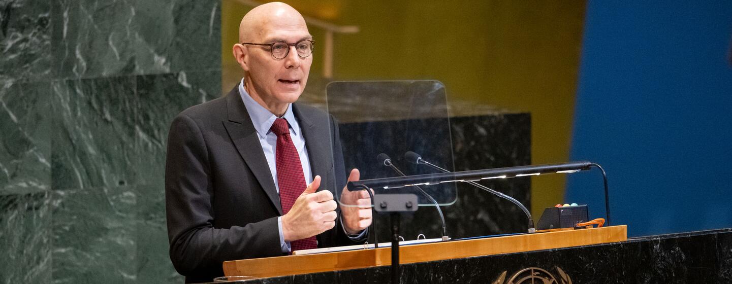Volker Türk, haut-commissaire des Nations unies aux droits de l'homme, chauve avec des lunettes, un costume et une cravate rouge, s'exprime sur un podium avec l'emblème de l'ONU lors d'une réunion commémorative de l'Assemblée générale de l'ONU.