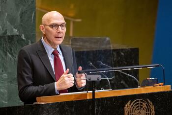 Volker Türk, haut-commissaire des Nations unies aux droits de l'homme, chauve avec des lunettes, un costume et une cravate rouge, s'exprime sur un podium avec l'emblème de l'ONU lors d'une réunion commémorative de l'Assemblée générale de l'ONU.