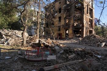 Ruins of a residential building destroyed by shelling stand next to a children's playground in Druzhkivka, Donetsk region, Ukraine. Debris, collapsed walls and twisted metal dominate the area, a stark reminder of the risks families face in frontline communities of eastern Ukraine.