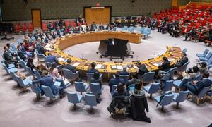 A wide view of the United Nations Security Council meeting on threats to international peace and security, with delegates seated around a large oval table.
