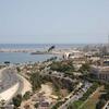 A panoramic view of Tripoli, Libya, showcasing the city's coastal layout, harbor, and surrounding urban areas from the rooftop of the Radisson Blu hotel.