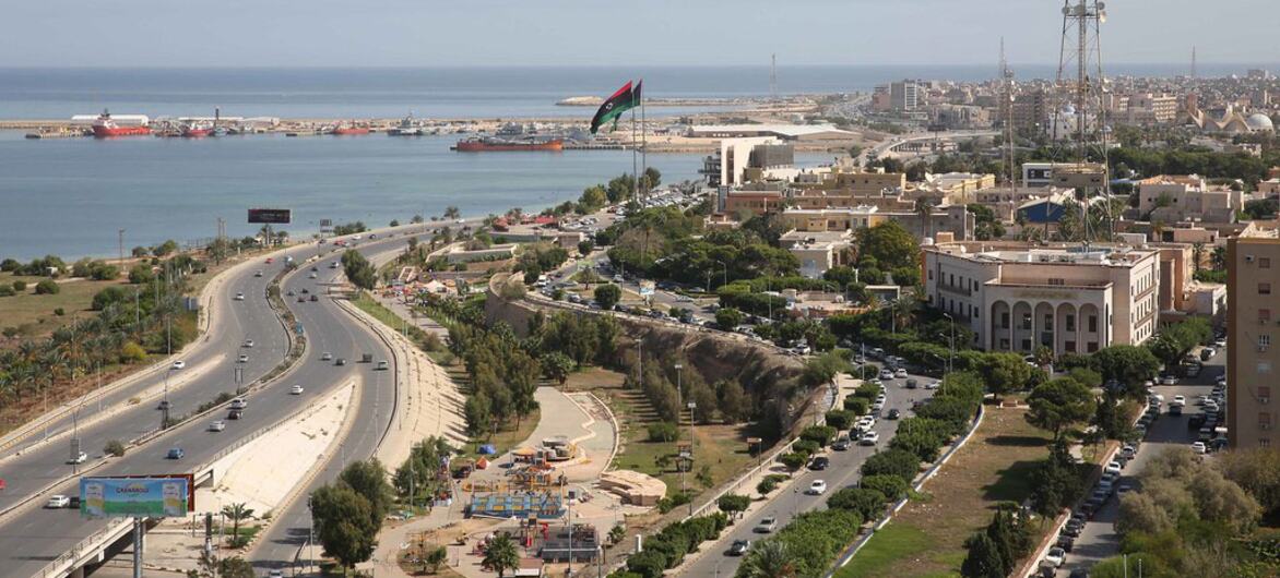 A panoramic view of Tripoli, Libya, showcasing the city's coastal layout, harbor, and surrounding urban areas from the rooftop of the Radisson Blu hotel.