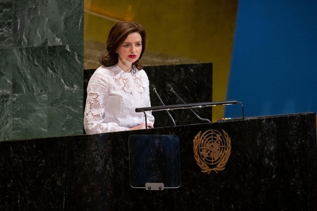 Une femme en blouse blanche à dentelle parle sur un podium orné de l'emblème des Nations Unies lors de la 23e réunion plénière de la 11e session spéciale d'urgence sur l'Ukraine.