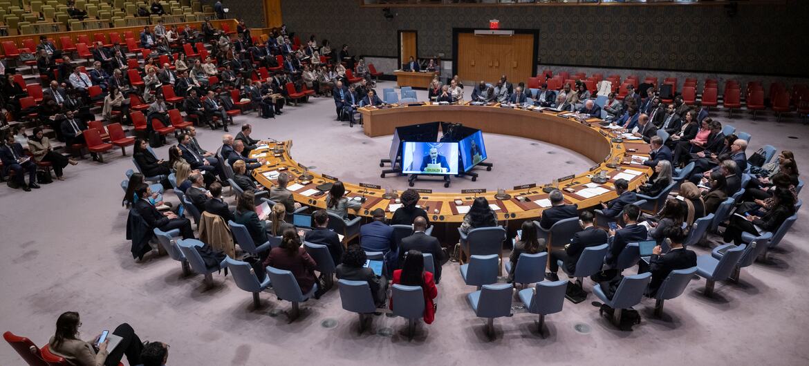 A wide view of the UN Security Council meeting on the situation in the Middle East, including the Palestinian question, with a speaker on a large screen.