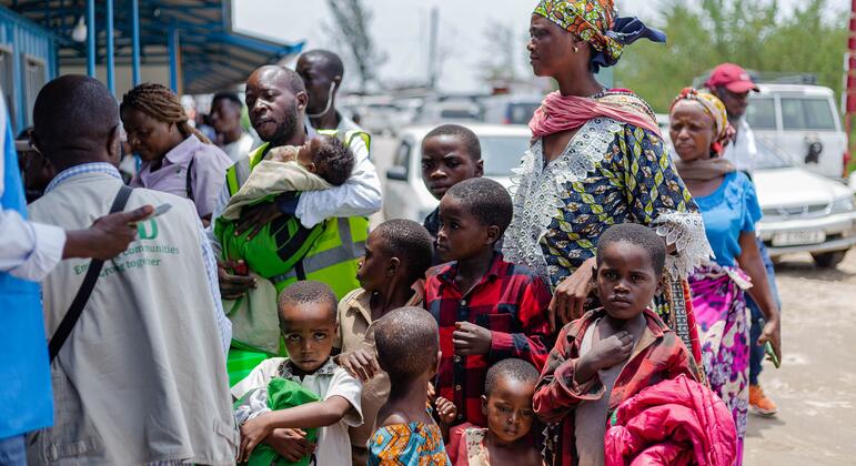 Un groupe de réfugiés africains, dont des femmes et des enfants, font la queue pour s'inscrire auprès d'un travailleur du HCR en RDC.