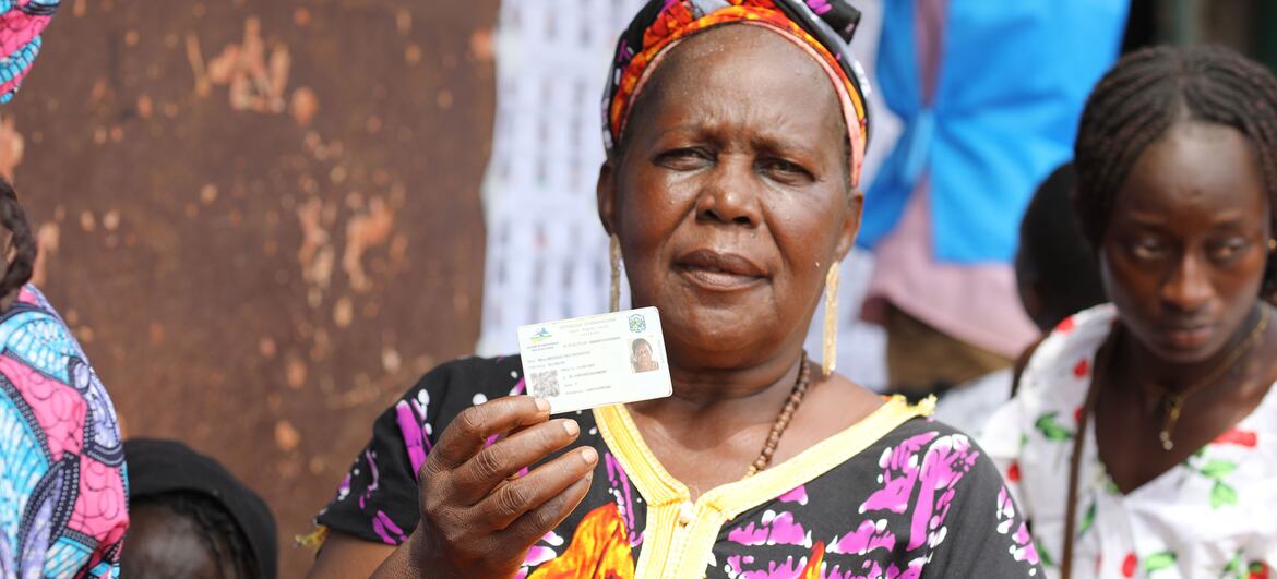 A woman in Central African Republic holds up her voter ID card at a polling station during the 2025-2026 elections.