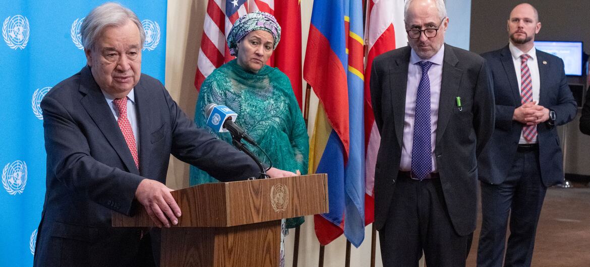 UN Secretary-General António Guterres speaking at a podium during a Security Council media stakeout about the situation in the Middle East, with other officials standing behind him.