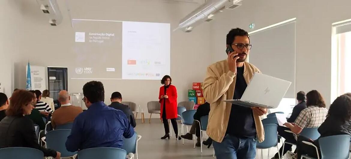 Uma apresentação de conferência sobre a Governação Digital em Portugal no evento UNU eGov, com um orador num pódio e uma audiência presente.