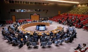 Wide view of the United Nations Security Council chamber during a debate on reaffirming the international rule of law, with delegates seated around a large circular table.
