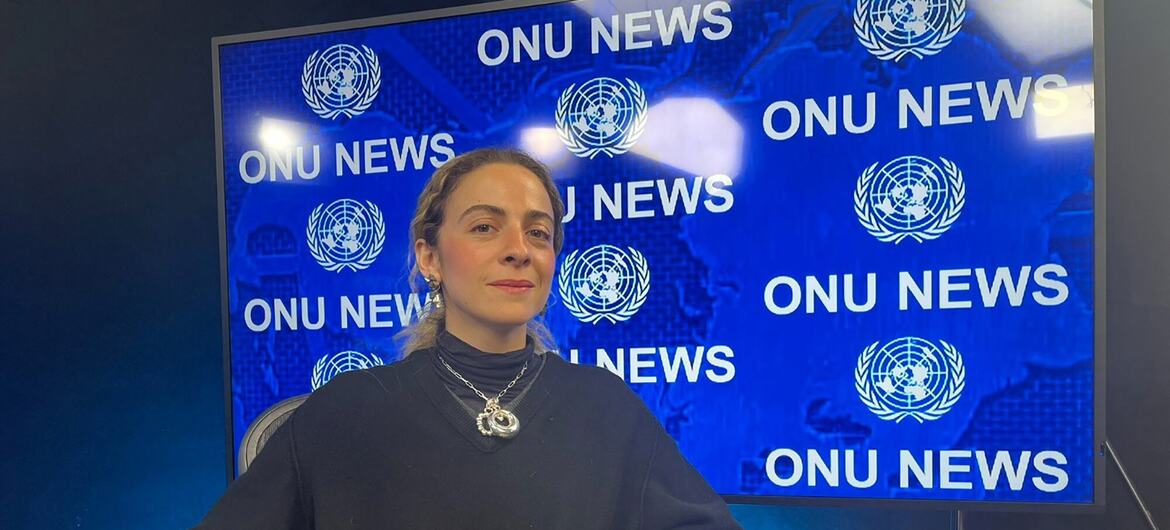 Constança Entrudo, uma mulher com cabelos castanhos claros, está sentada em frente a uma tela azul que exibe 'ONU NEWS' e o logotipo das Nações Unidas.