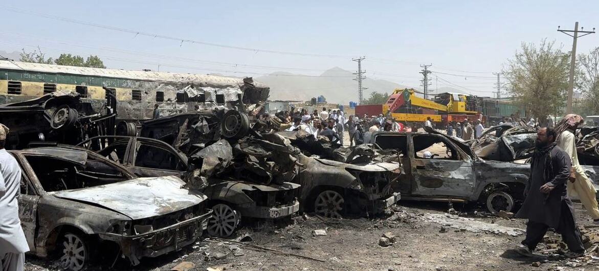 کوئٹہ، پاکستان میں ٹرین اور گاڑی کے حملے کے نتیجے میں تباہ شدہ گاڑیاں اور اس مقام پر موجود لوگوں کی بھیڑ۔