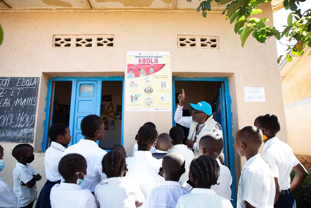 Un agent WASH de l'UNICEF explique les mesures de prévention de l'Ebola à un groupe d'élèves d'une école primaire à Bunia, en République démocratique du Congo.